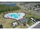 Aerial view of a community pool with a lake and surrounding neighborhood in the background at 4316 Carrabelle River Ln, Lakeland, FL 33811