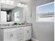 Bright bathroom with double vanity, granite countertop, framed mirror, decorative light fixtures, and modern finishes at 465 Britten Dr, Kissimmee, FL 34758
