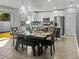 Open-concept dining area flowing into the kitchen, featuring a dining table set for six, and modern light fixture at 465 Britten Dr, Kissimmee, FL 34758