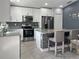 Modern kitchen featuring stainless steel appliances, granite countertops, stylish backsplash, and a central island with seating at 465 Britten Dr, Kissimmee, FL 34758