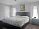 Serene main bedroom with a queen-size bed, bedside tables, windows with curtains and ample natural light at 465 Britten Dr, Kissimmee, FL 34758