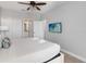 Primary bedroom featuring a ceiling fan, white bedding and ensuite bathroom at 482 Captiva Dr, Davenport, FL 33836