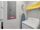 Bright laundry area with a white washing machine, ironing board, and folded yellow towels at 482 Captiva Dr, Davenport, FL 33836