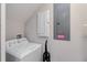 Bright laundry area with a white washing machine, utility sink hookup, and electrical panels at 482 Captiva Dr, Davenport, FL 33836