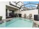 The screened-in pool has steps, safety fencing and outdoor seating for relaxing by the water at 482 Captiva Dr, Davenport, FL 33836