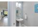Stylish powder room with a pedestal sink, oval mirror, and tasteful decor at 482 Captiva Dr, Davenport, FL 33836