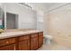 Bathroom with a large mirror, vanity with cabinets, toilet and a shower over bath at 5335 Coral Vine Ln, Kissimmee, FL 34758