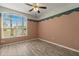Bright bedroom featuring wood floors, ceiling fan, and a large window offering ample natural light at 5335 Coral Vine Ln, Kissimmee, FL 34758