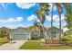 Charming home with a two-car garage, manicured lawn, and mature palm trees on a sunny day at 5335 Coral Vine Ln, Kissimmee, FL 34758
