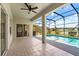 Covered patio with tile flooring overlooking a screened pool and scenic backyard and lake at 5335 Coral Vine Ln, Kissimmee, FL 34758