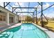 Sparkling pool enclosed by a screened lanai offering beautiful views of the lush backyard at 5335 Coral Vine Ln, Kissimmee, FL 34758