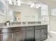 Bathroom featuring dual sinks, granite counter tops, dark wood vanity, and ample lighting at 5412 Solterra Cir, Davenport, FL 33837