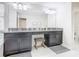 Bathroom featuring dark cabinets, a granite countertop, double sinks, and a large mirror at 5412 Solterra Cir, Davenport, FL 33837