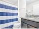Bathroom featuring a single granite vanity, toilet, and a blue-striped shower curtain at 5412 Solterra Cir, Davenport, FL 33837