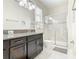 Bathroom featuring a glass shower, granite counter tops, dark wood vanity, and ample lighting at 5412 Solterra Cir, Davenport, FL 33837
