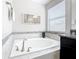 Bathroom featuring a large bathtub with white tile surround and a dark vanity nearby at 5412 Solterra Cir, Davenport, FL 33837