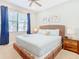 Bright bedroom featuring a woven headboard, ceiling fan, and large window with natural light at 5412 Solterra Cir, Davenport, FL 33837