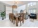 This dining room features a woven chandelier, tall ceilings, large windows, and an open concept that flows into the living room at 5412 Solterra Cir, Davenport, FL 33837