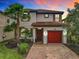 Charming two-story home boasts a red-tiled roof, red garage door and lush landscaping, creating inviting curb appeal at 5412 Solterra Cir, Davenport, FL 33837
