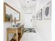 Bright and airy hallway with white tile floors, a decorative table with a large mirror, and modern artwork at 5412 Solterra Cir, Davenport, FL 33837