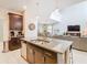 Kitchen island featuring stainless steel appliances, dark cabinets, and seating area at 5412 Solterra Cir, Davenport, FL 33837