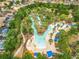 Aerial shot of a winding lazy river with lush trees, seating areas, and colorful inner tubes at 5412 Solterra Cir, Davenport, FL 33837