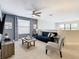 Living room featuring a blue couch, patterned chair, gray walls, and a ceiling fan at 5412 Solterra Cir, Davenport, FL 33837