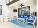 Inviting outdoor patio featuring a ceiling fan, dining table, and comfortable seating area with blue accents at 5412 Solterra Cir, Davenport, FL 33837