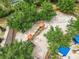 Aerial view of a community playground with slides, swings, and climbing structures surrounded by trees at 5412 Solterra Cir, Davenport, FL 33837