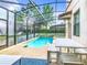 A beautiful private screened in pool with a table and chairs on the pool deck at 5412 Solterra Cir, Davenport, FL 33837