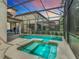 Relax in the screened-in pool area with a jacuzzi and inviting outdoor lounge furniture; perfect for entertaining at 5412 Solterra Cir, Davenport, FL 33837