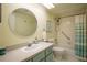 Bathroom features a single sink vanity, round mirror and a shower with a safety bar at 601 W Old Us Highway 441 # 9B, Mount Dora, FL 32757