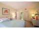 Bright bedroom featuring a comfortable bed with floral pillows and a bathroom entrance at 601 W Old Us Highway 441 # 9B, Mount Dora, FL 32757
