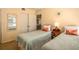 Cozy bedroom with two twin beds, and an antique mirror at 601 W Old Us Highway 441 # 9B, Mount Dora, FL 32757