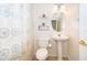 Clean half bath features a pedestal sink, stylish faucet, overhead lighting, toilet, and a decorative mirror at 6274 Bristol Channel Way, Orlando, FL 32829