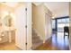 Bright entryway features hardwood floors, stairs, closet, and powder room with pedestal sink and decorative mirror at 6274 Bristol Channel Way, Orlando, FL 32829
