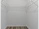 Walk-in closet features built-in shelving and contemporary wood-look floors at 6713 Cherry Rd, Ocala, FL 34472