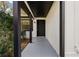 Covered front porch with black trim, white siding, and gray flooring is a cozy spot to enter the home at 6713 Cherry Rd, Ocala, FL 34472