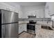 Kitchen with granite countertops, stainless steel appliances, white cabinets, and tiled backsplash at 6713 Cherry Rd, Ocala, FL 34472