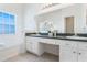 Bright bathroom with double sinks, vanity, neutral tile flooring, and large mirror at 7911 Magnolia Bend Ct, Kissimmee, FL 34747