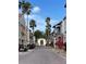 Picturesque community street with palm trees, colorful shops, and parked golf carts at 801 San Raphael St, Poinciana, FL 34759