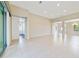 Spacious living room with sliding glass doors, neutral walls, and tile flooring, leading to a serene outdoor space at 801 San Raphael St, Poinciana, FL 34759