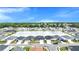 An aerial view captures a charming community with lush trees surrounding a tranquil neighborhood lake at 8043 Brookeshire Dr, Lakeland, FL 33809