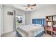 Comfortable bedroom featuring a blue velvet headboard, ceiling fan and a window with natural light at 8043 Brookeshire Dr, Lakeland, FL 33809