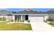 Inviting home featuring a two-car garage, landscaped front yard, and a cozy porch with seating at 8043 Brookeshire Dr, Lakeland, FL 33809
