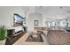 Spacious open-concept living room featuring a large TV, L-shaped sofa and decorative plants at 8043 Brookeshire Dr, Lakeland, FL 33809