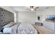 The main bedroom features a gray tufted headboard, soft carpeting, and a ceiling fan for comfort at 8043 Brookeshire Dr, Lakeland, FL 33809