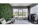 Enclosed porch has stylish furniture and a green wall with a view of the lake at 8043 Brookeshire Dr, Lakeland, FL 33809