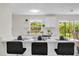 Bright kitchen with a breakfast bar, modern countertops, and sliding glass doors to the backyard at 822 Oakview Dr, New Smyrna Beach, FL 32169