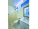 Well-lit bathroom with a white vanity, toilet, and mirror; features marble tile flooring and a clerestory window at 871 Blairmont Ln, Lake Mary, FL 32746
